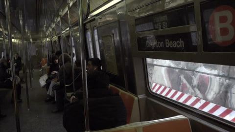 panning across B train subway with graffiti on either side of